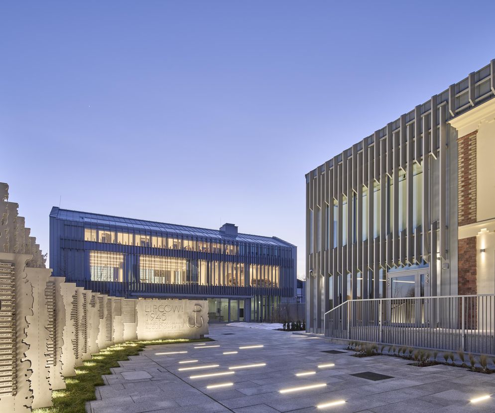 Dom Turka – Dom Pamięci Obławy Augustowskiej w Augustowie, z jasnymi elewacjami i nowoczesnym skrzydłem, którego pionowe rytmy nawiązują do natury. Projekt wyróżnia się poszanowaniem historii i nowoczesnym podejściem, o czym przeczytasz na Architektura Murator Plus.