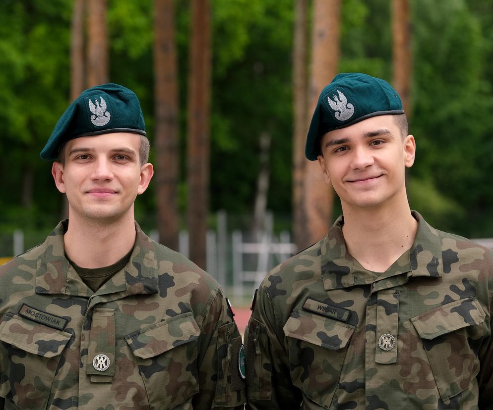 Mateusz Kowalski jako Mateusz Mostowiak i Jakub Sirko jako Janek Winiar w strojach moro z zielonymi beretami, stojący na tle zieleni. Ich przyjaźń oraz tajemnice rodzinne to główne wątki w serialu. Więcej o ich losach na Super Seriale.