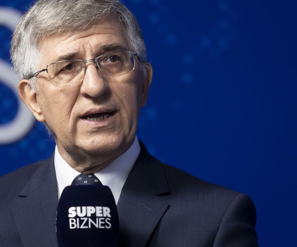 Zbigniew Derdziuk, prezes ZUS, w trakcie wywiadu.  Mężczyzna w okularach i garniturze, trzyma mikrofon z logo Super Biznes.  Artykuł dotyczy opóźnień w wypłatach rent wdowich oraz innych kwestii związanych z ZUS.  Więcej informacji na ten temat znajdziesz na portalu Super Biznes.