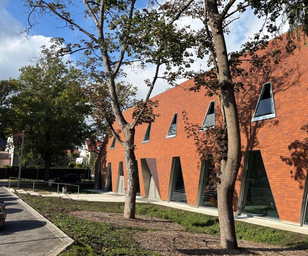 Nowy Ośrodek Szkoleniowo-Naukowy Okręgowej Izby Lekarskiej w Gdańsku, z fasadą z czerwonej cegły i spadzistym dachem. Budynek, wpisujący się w willową dzielnicę Aniołki, z charakterystycznymi skośnymi oknami, otoczony zielenią i drzewami. Architektura Murator Plus opisywała jego projekt.