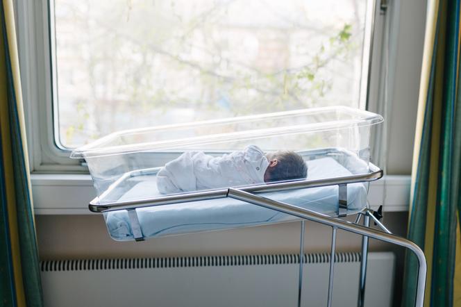 Noworodek w łóżeczku szpitalnym