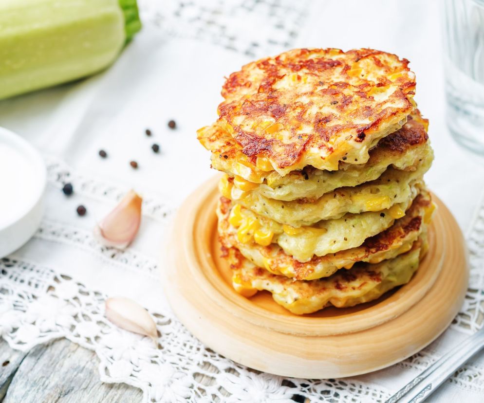 Składniki: 
 1 puszka kukurydzy, 
 2 jajka, 
 2/3 szklanki mąki pszennej, 
 1/4 szklanki mąki kukurydzianej, 
 2/3 szklanki maślanki, 
 2 cebule dymki, 
 płaska łyżeczka proszku do pieczenia, 
 sól i pieprz do smaku, 
 olej do smażenia (np. kokosowy) 
 Przygotowanie: 
 Kukurydzę odcedź i odłóż ją do osobnej miski. Szalotkę posiekaj razem ze szczypiorkiem. Wymieszaj mąkę pszenną, kukurydzianą i proszek do pieczenia. Jajka wbij do miski, dodaj maślankę i roztrzep. Połącz partiami suche składniki z mokrymi i wymieszaj na gładką masę. Dodaj kukurydzę, cebulkę, szczypiorek i przypraw do smaku. Smaż placki na rumiano z obu stron. Z przepisu wychodzą 3 porcje.