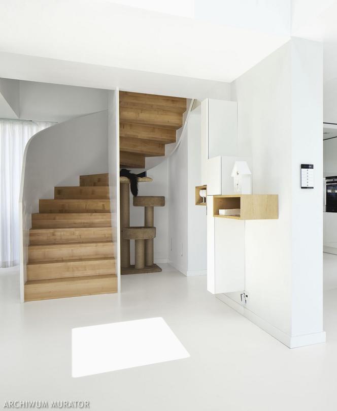 Białe wnętrze z drewnianymi schodami