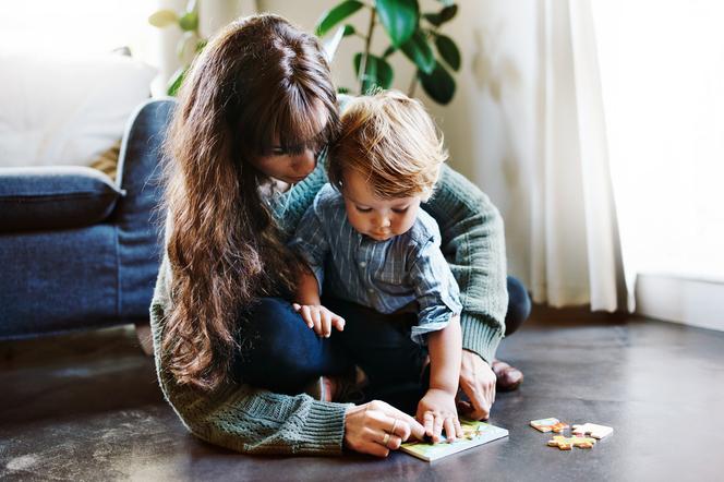 mama układająca z synkiem na podłodze układankę 