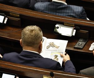 W  czasie obrad Sejmu poseł przeglądał katalog z bronią