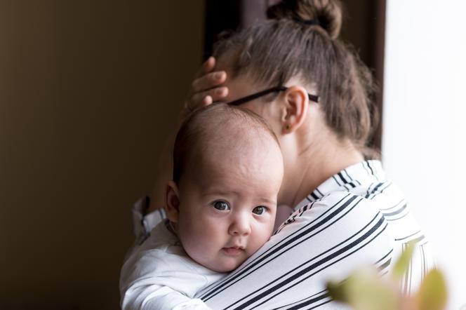 Kobieta w depresji trzyma w ramionach dziecko