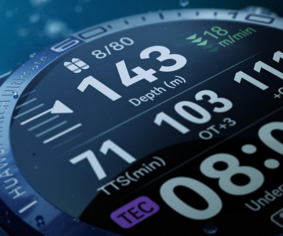 Smartwatch Huawei Watch Ultimate z widocznym podwodnym interfejsem pokazującym głębokość 143 m, czas zanurzenia i aktualną godzinę. Na portalu Super Biznes przeczytasz o promocjach serwisowych Huawei.