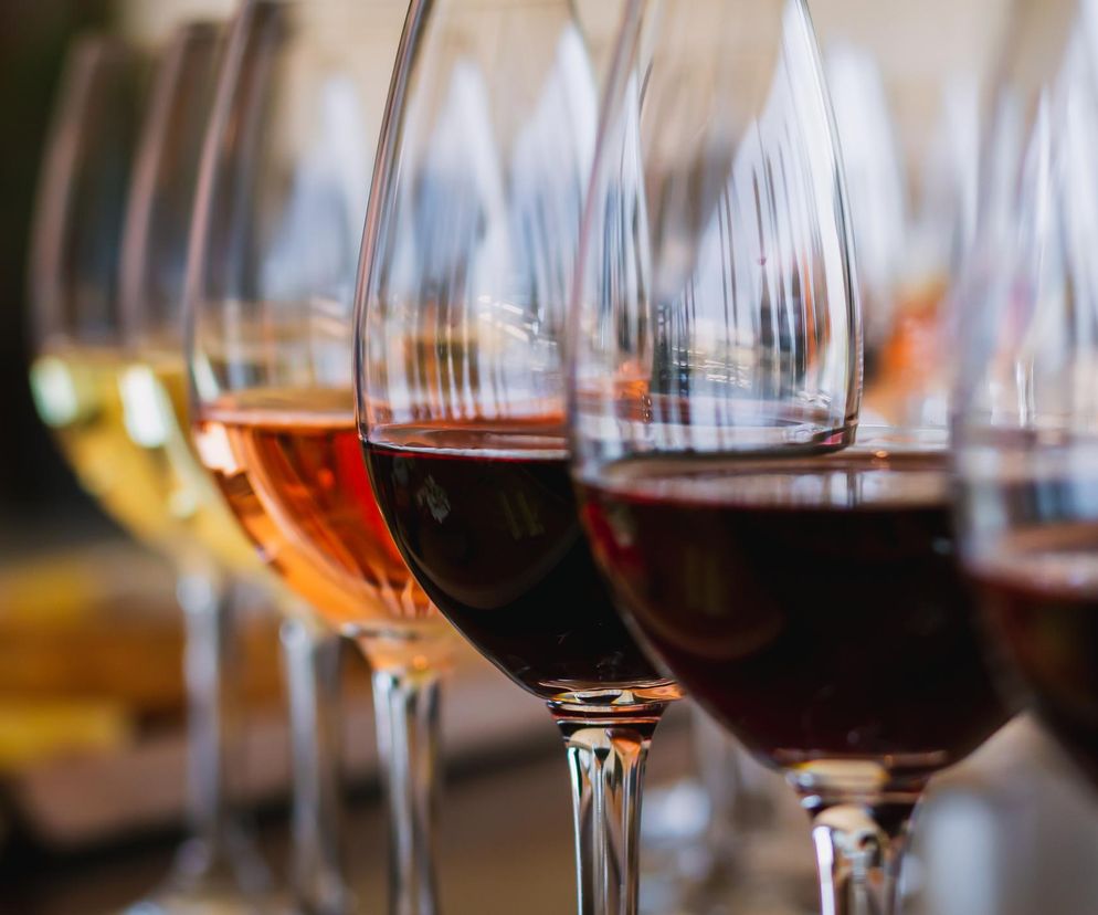 Kieliszki z winem – od białego przez różowe po czerwone, ustawione w rzędzie, symbolizują mit o bezpiecznym spożyciu alkoholu, obalany przez badania naukowe dotyczące zdrowia mózgu. Artykuły na Poradnik Zdrowie przestrzegają przed ryzykiem demencji związanym z każdym kieliszkiem.