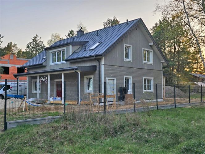Prefabrykowany dom w Warszawie już z drewnianą okładziną ścian - trwają prace wykończeniowe