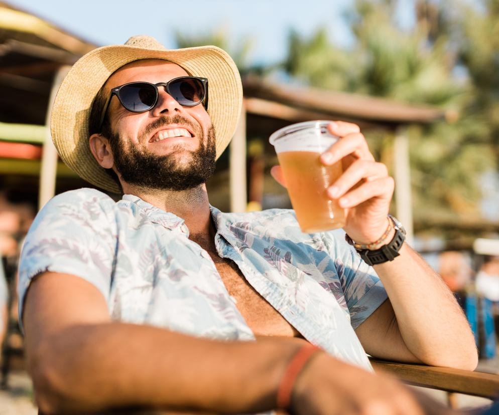 Mężczyzna pije piwo na plaży