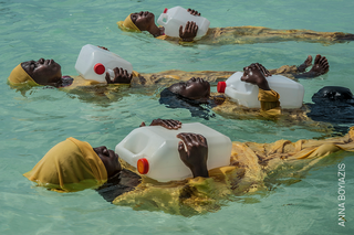 Kobiety utrzymujące się na wodzie przy pomocy plastikowych pojemników
