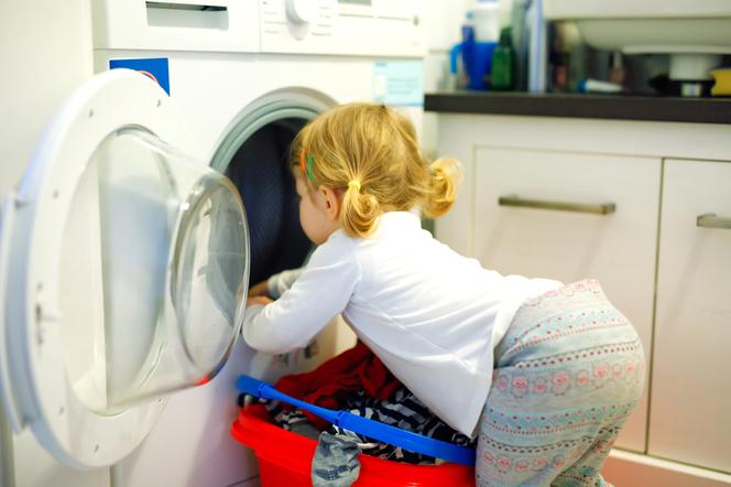 Dziecko wyjmuje rzeczy z pralki