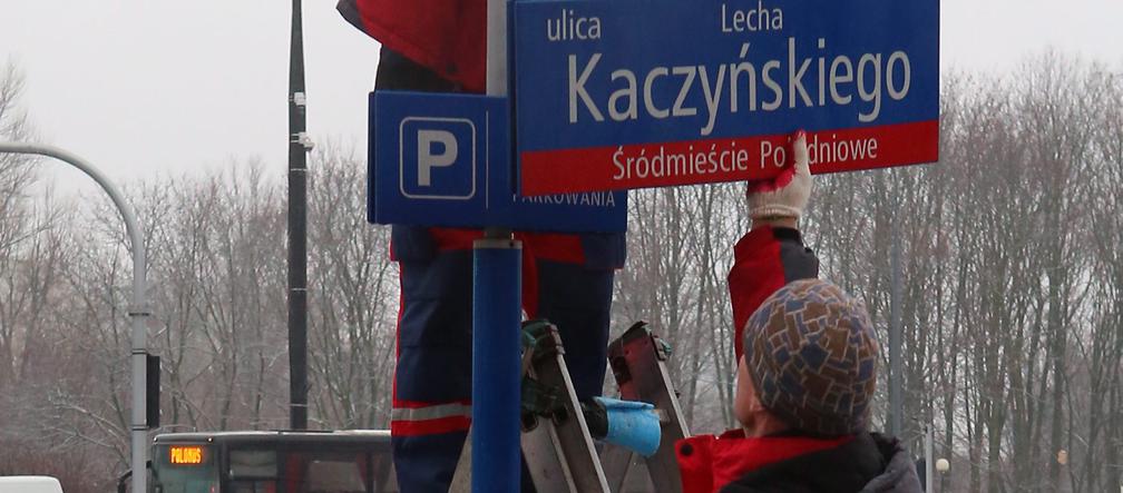 Dekomunizacja Warszawy. Zdejmowanie tablicy z Aleją Lecha Kaczyńskiego, zakładanie na powrót Armii Ludowej.