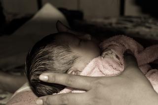 Zasnęła przy karmieniu, nad ranem dziecko nie oddychało. Jak spać z niemowlęciem, by było bezpieczne?