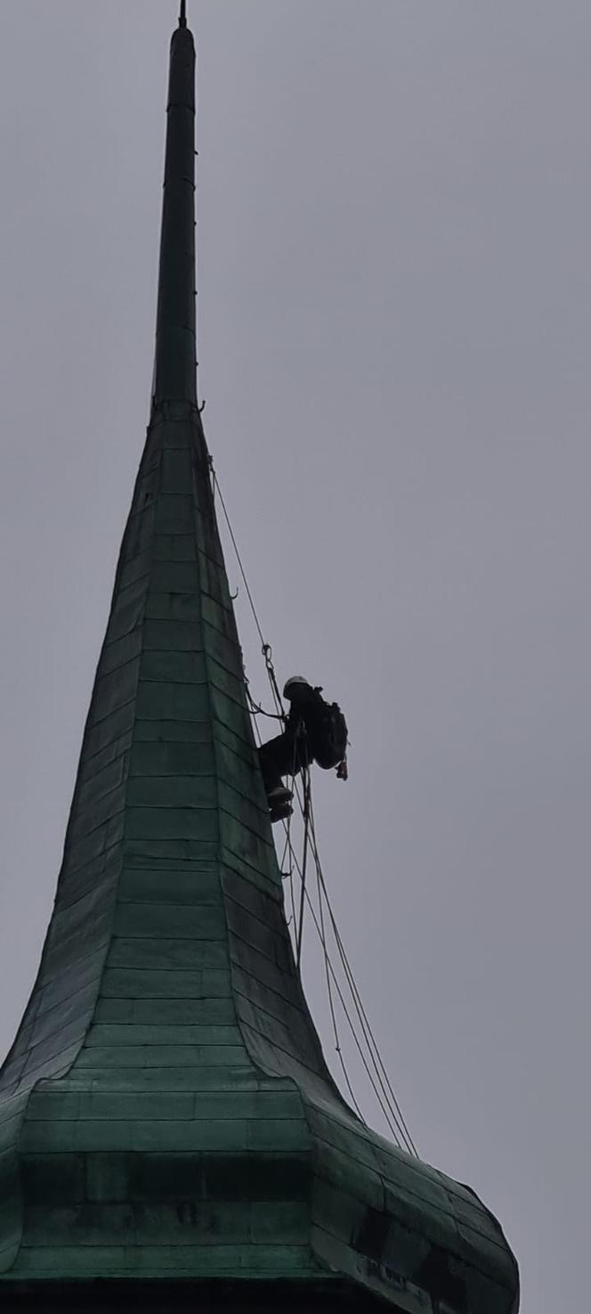 Alpinista na wieży kościoła w Białogardzie