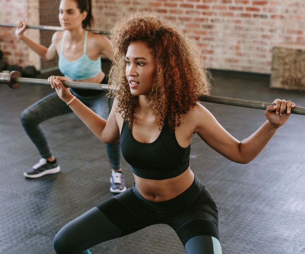 Przysiady z dodatkowym obciążeniem rewelacyjnie modelują pośladki.