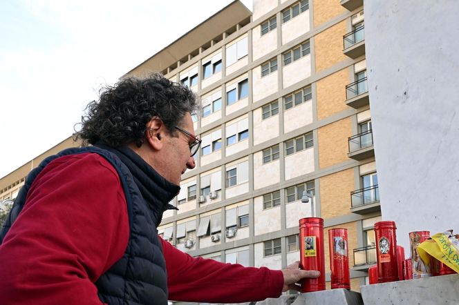 Wierni modlą się o zdrowie Franciszka przed pomnikiem Jana Pawła II. Składają kartki z życzeniami i wiązanki z białych róż