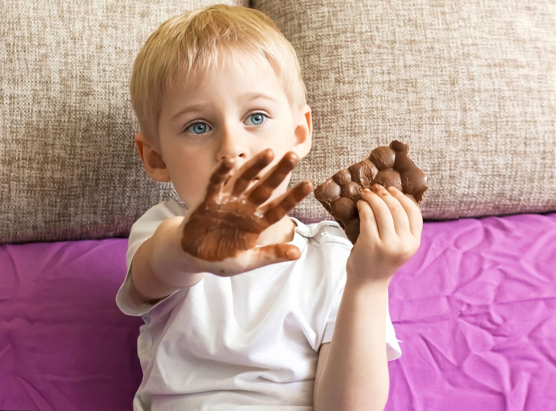 Дядя тянет руку в руке шоколадка. Конфетка в руке. Конфеты детям. Мальчик ест шоколад.