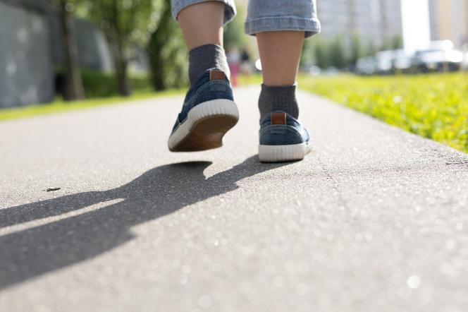 Nogi chłopca spacerującego samotnie ulicą