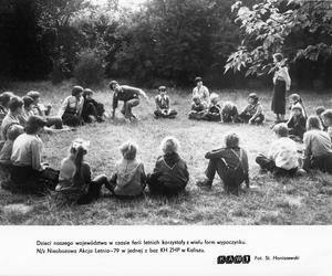 Fotografia prezentująca grupę dzieci biorących udział w nieobozowej letniej akcji w 1979 r. w jednej z baz ZHP w Kaliszu. APK, Urząd Wojewódzki w Kaliszu