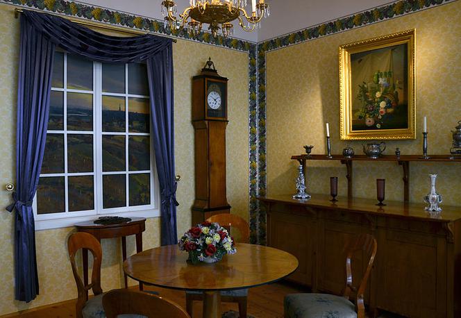 Niemiecka jadalnia w stylu biedermeier. Z jasną barwą prostych, funkcjonalnych mebli kontrastują nieco bardziej intensywne kolory tapet i tkanin.