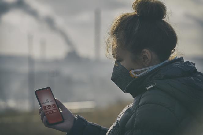 Kobieta mierzy stężenie smogu w powietrzu