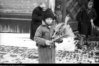 Chłopiec sprzedający palmy wielkanocne przed kościołem w Krakowie (1931)
