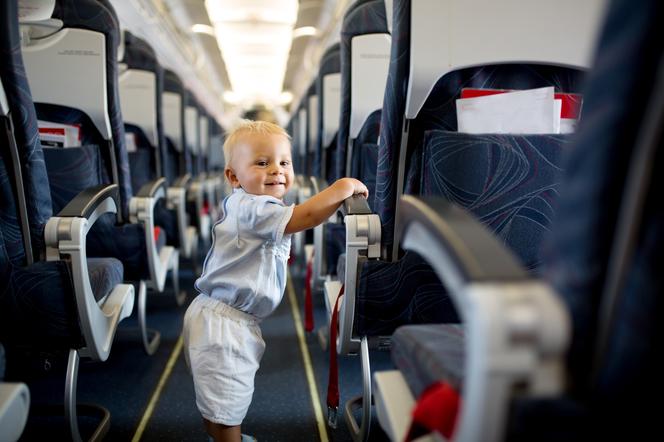 dziecko w samolocie, spacerujące między siedzeniami