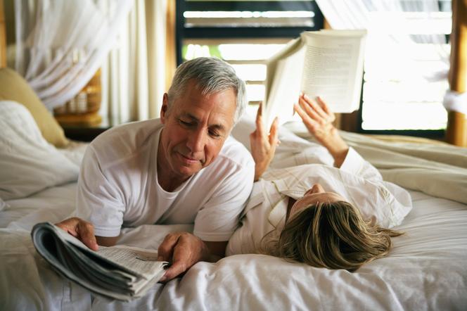 Seniorzy czytają na łóżku