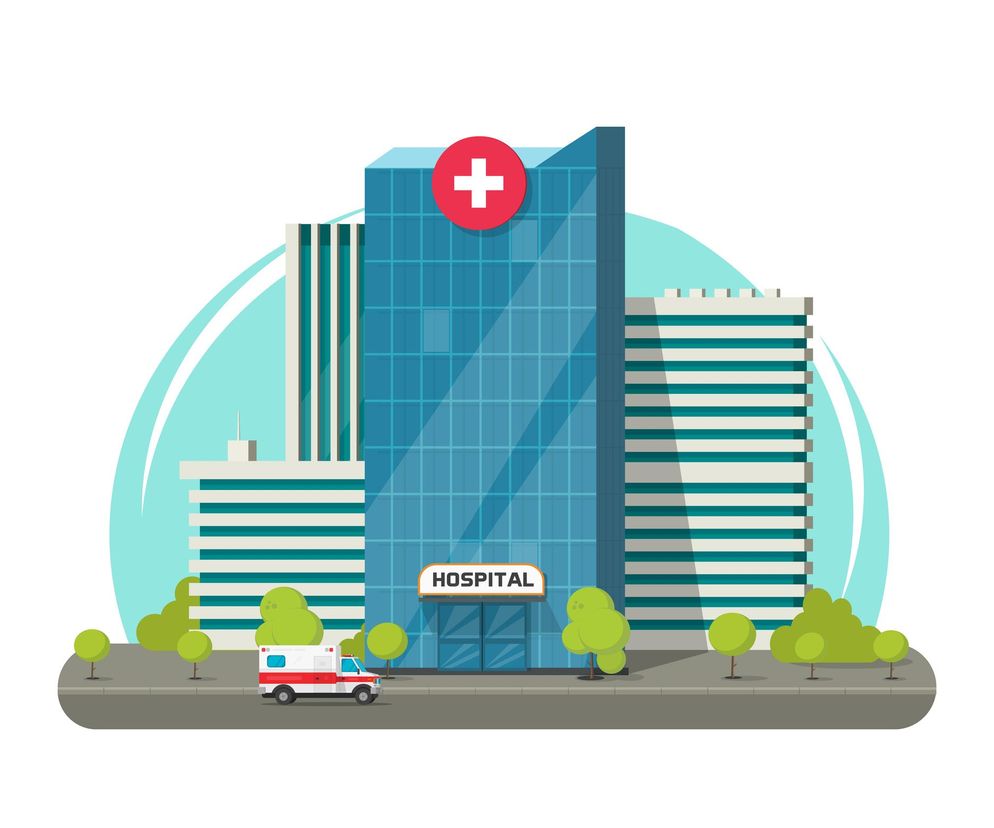 Nowoczesny, przeszklony budynek szpitala z czerwonym krzyżem na szczycie i napisem HOSPITAL nad wejściem. Przed budynkiem, na ulicy, zaparkowana jest karetka pogotowia. Ilustracja symbolizuje szpitale przekształcone w zakaźne, o których można przeczytać na portalu Poradnik Zdrowie.