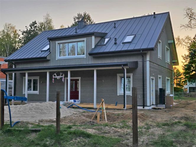 Prefabrykowany dom w Warszawie już z drewnianą okładziną ścian - trwają prace wykończeniowe