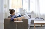 Lampa podłogowa z ładowarką ustawiona przy sofie