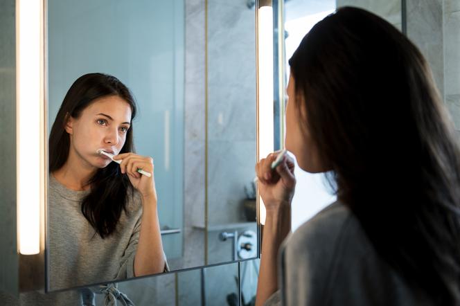 Zbliżenie na młodą kobietę, która myje zęby 