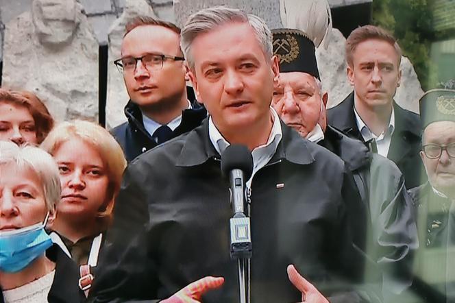 Robert Biedroń na tle religijnego hasła