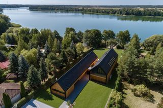Dom na Kujawach - dwie połączone nowoczesne stodoły nad jeziorem