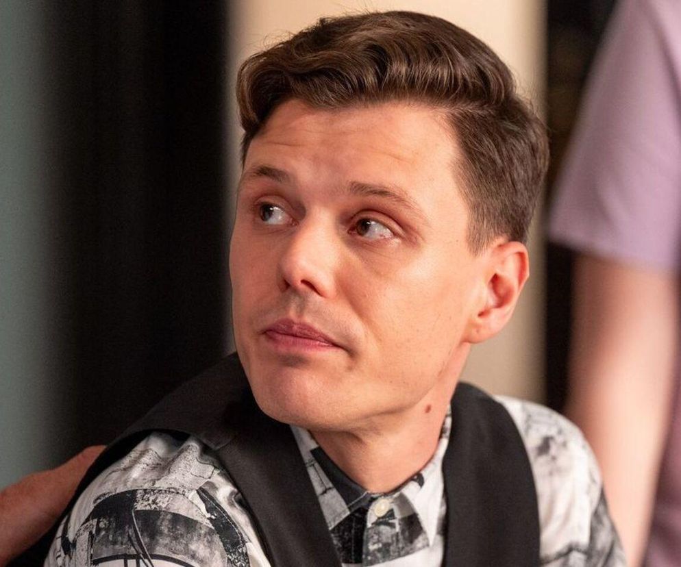 Aktor Jakub Szlachetka jako Kacper z serialu Barwy szczęścia z zamyślonym wyrazem twarzy, mający na sobie koszulę we wzory i czarną kamizelkę. Zdjęcie ilustruje sceny dramatu Kacpra w 3233 odcinku, o którym przeczytasz więcej na Super Seriale.