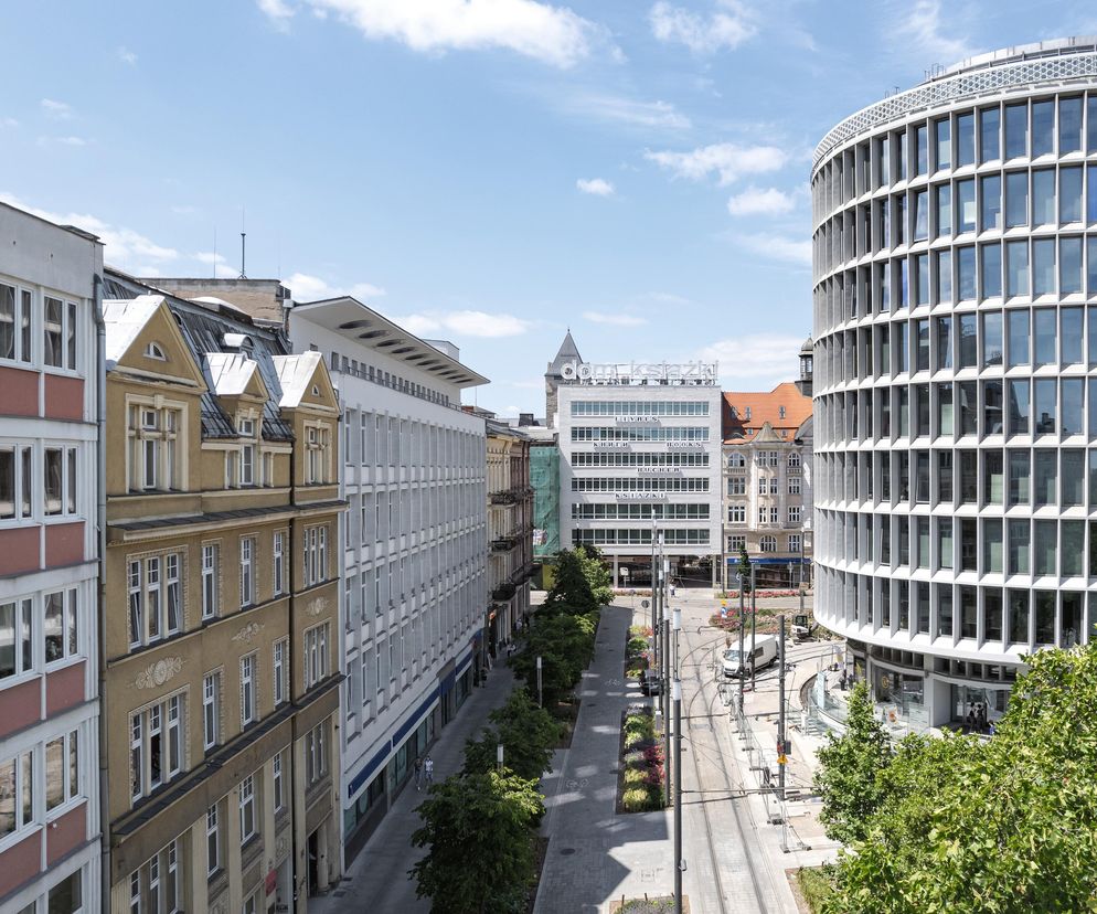 Okrąglak w Poznaniu, widoczny z lotu ptaka, z fasadą z białego betonu i przeszkleniami, to ikona modernizmu PRL-u. Po lewej kamienice w stylu eklektycznym i neorenesansowym, po prawej kwadratowy budynek Domu Książki. W dole widoczne tory tramwajowe, zieleń miejska. O architekturze Okrąglaka przeczytasz na Architektura Murator Plus.