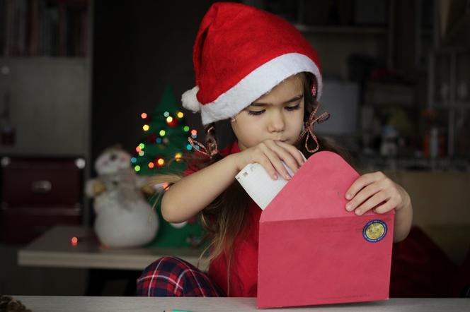 Dziewczynka przygotowuje list do świętego Mikołaja 