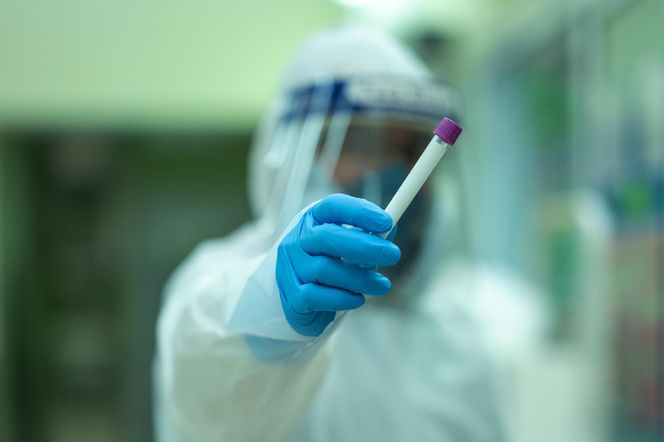 Mężczyzna w laboratorium z fiolką