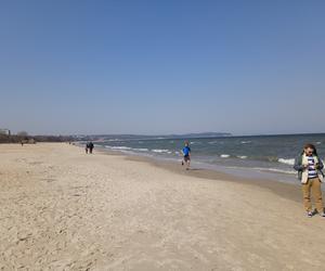 Mieszkańcy korzystają ze słonecznej pogody. Na plaży w Jelitkowie widać już pierwszych spacerowiczów!