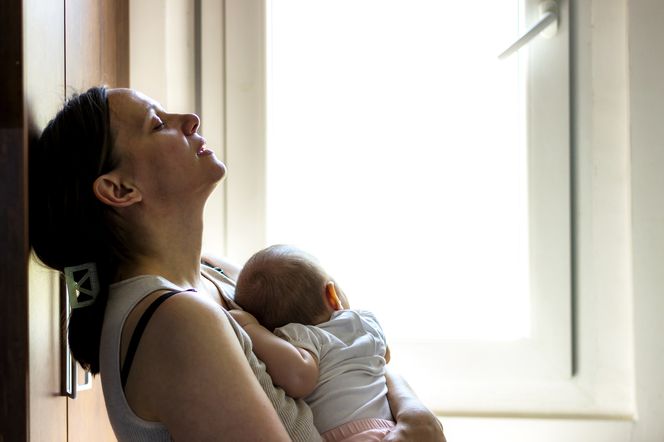 Smutna kobieta trzyma dziecko na rękach