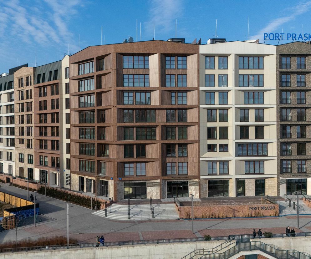 Widok z lotu ptaka na nowoczesny budynek mieszkalno-usługowy Port Praski przy Sierakowskiego 1 i 3, autorstwa Danuty Rydzewskiej i Anny Rydzewskiej-Szpak. Wielorodzinny obiekt z elewacją z cegły klinkierowej i kamienia idealnie wpisuje się w otoczenie, łącząc tradycję z nowoczesnością, co docenia Architektura Murator Plus.