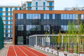 Szkoła przy skrzyżowaniu ul. Silnikowej i Hennela w Warszawie z fotowoltaiką na elewacji