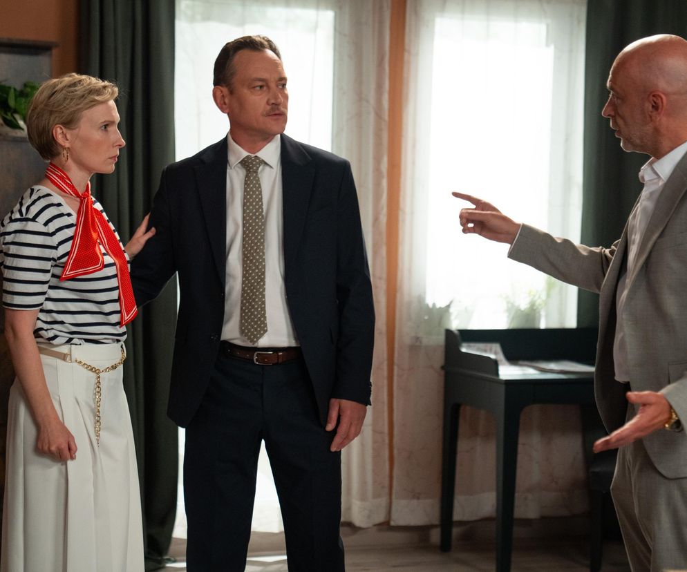 Sonia z Barw Szczęścia, ubrana w biało-granatowy T-shirt w paski i białe spodnie, z czerwoną apaszką, stoi obok Stefaniaka w garniturze. Mężczyźni dyskutują o tragicznym losie Soni, którą Stefaniak wyda bandycie Bazylowowi. Więcej o dramatycznych wydarzeniach w serialu Barwy szczęścia przeczytasz na portalu Super Seriale.