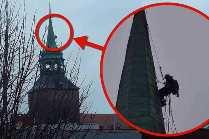 Alpinista na wieży kościoła w Białogardzie
