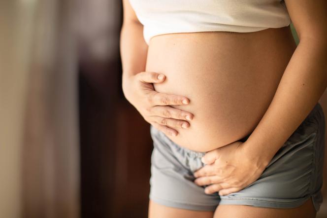 Kobieta w ciąży trzmajaca się za brzuch