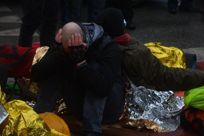 Ludzie leżą na ulicy w centrum Warszawy