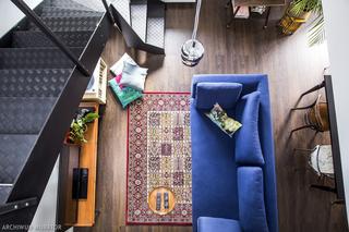 Granatowa sofa  na orientalnym dywanie w salonie