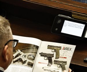 W  czasie obrad Sejmu poseł przeglądał katalog z bronią