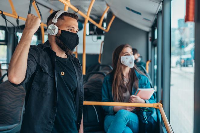 Ludzie w maseczkach jadą autobusem